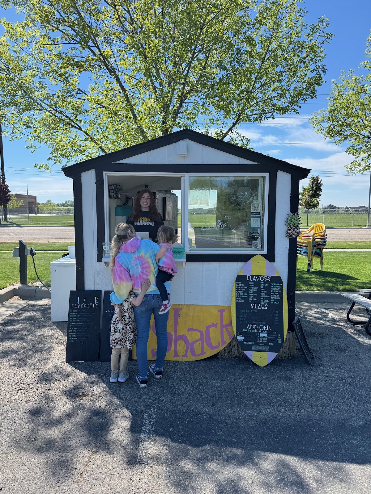 A family ordering shave ice at the walk-up window