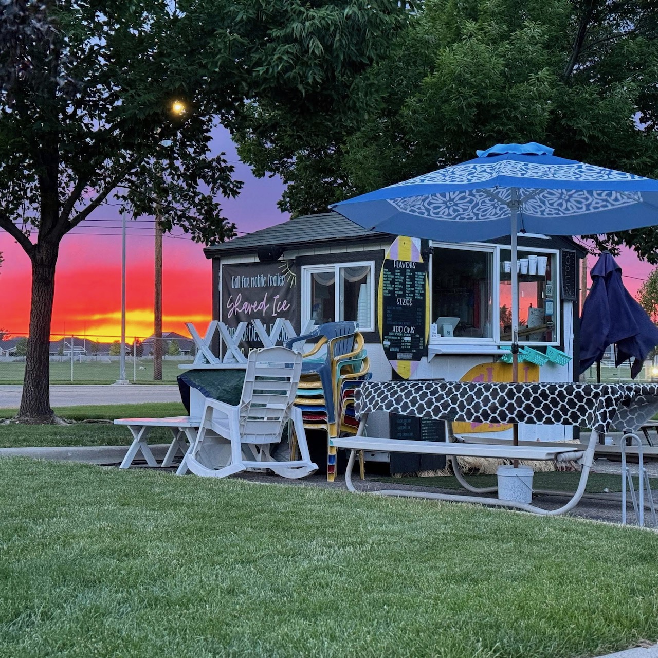 The Shack Shave Ice stand glowing at sunset with string lights